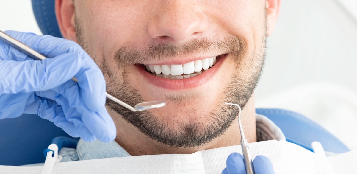 Young man at the dentist. Dental care, taking care of teeth. Picture with copy space for background.
